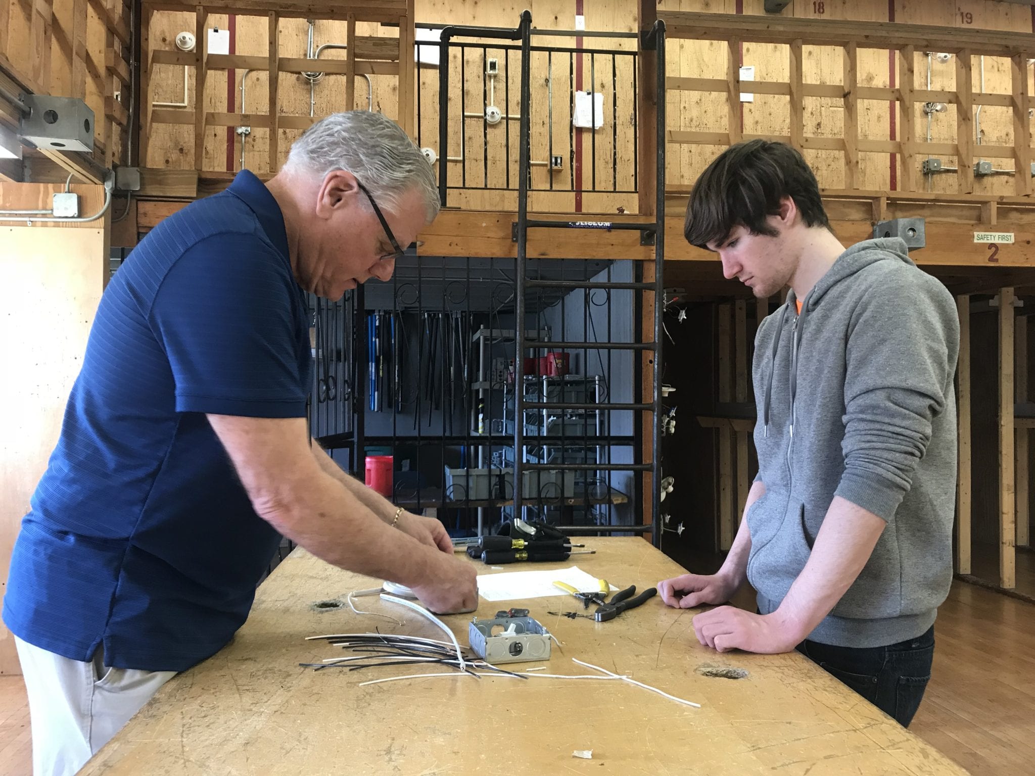 Electrical instructor Frank Barker works with Woburn High School senior Jean Luc Walsh on wiring a power switch. (Courtesy Photo)