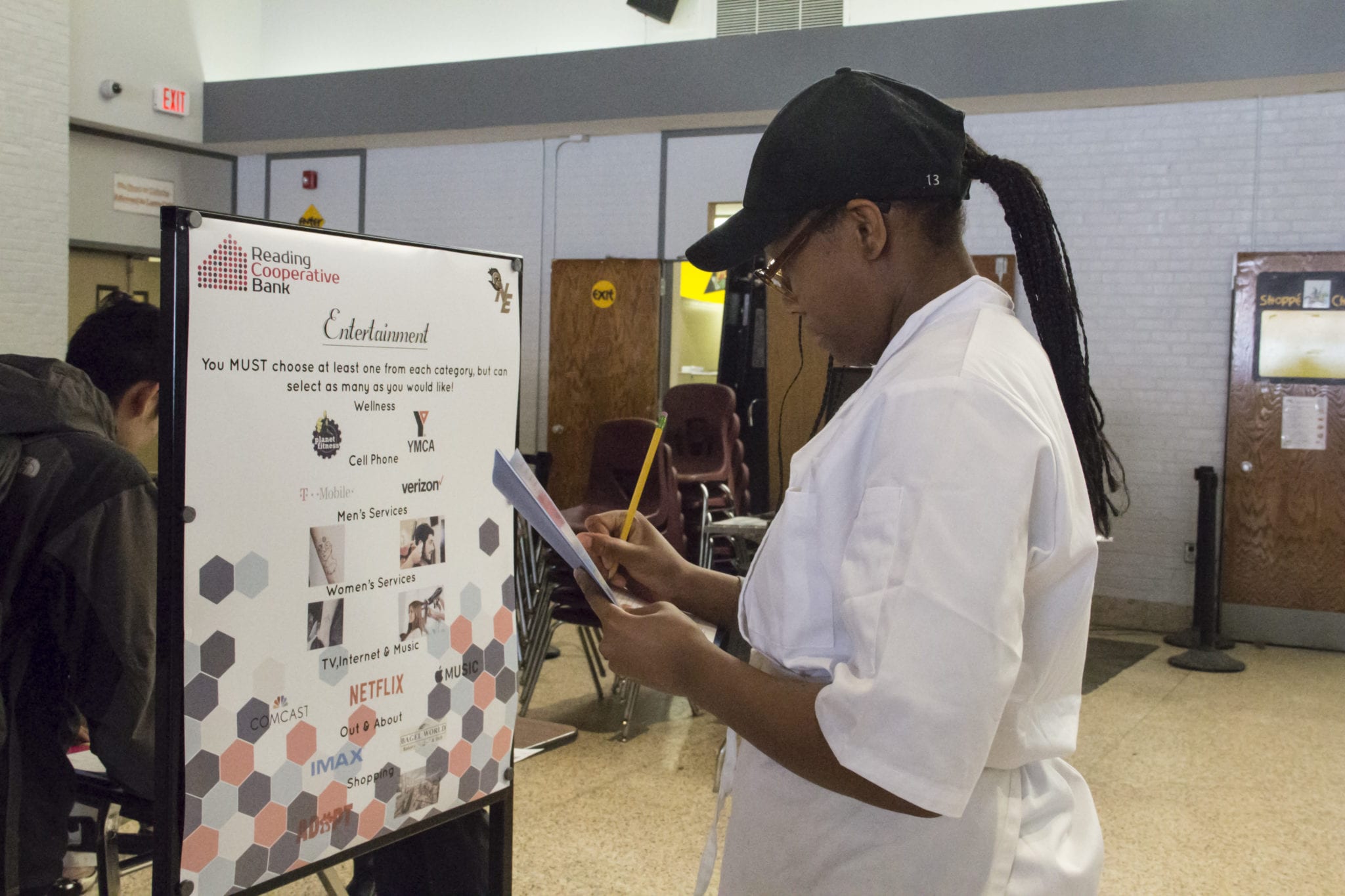 Malden resident Trinitee Arnold, a junior from the culinary shop, fills out her form at the entertainment section of the financial literacy fair. (Courtesy Photo Northeast Metro Tech)